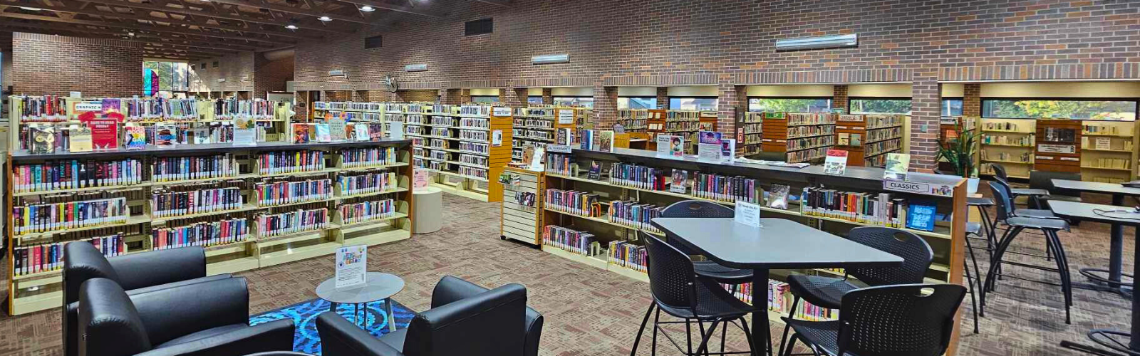 The inside of the library, showing rows of shelving with books and work tables