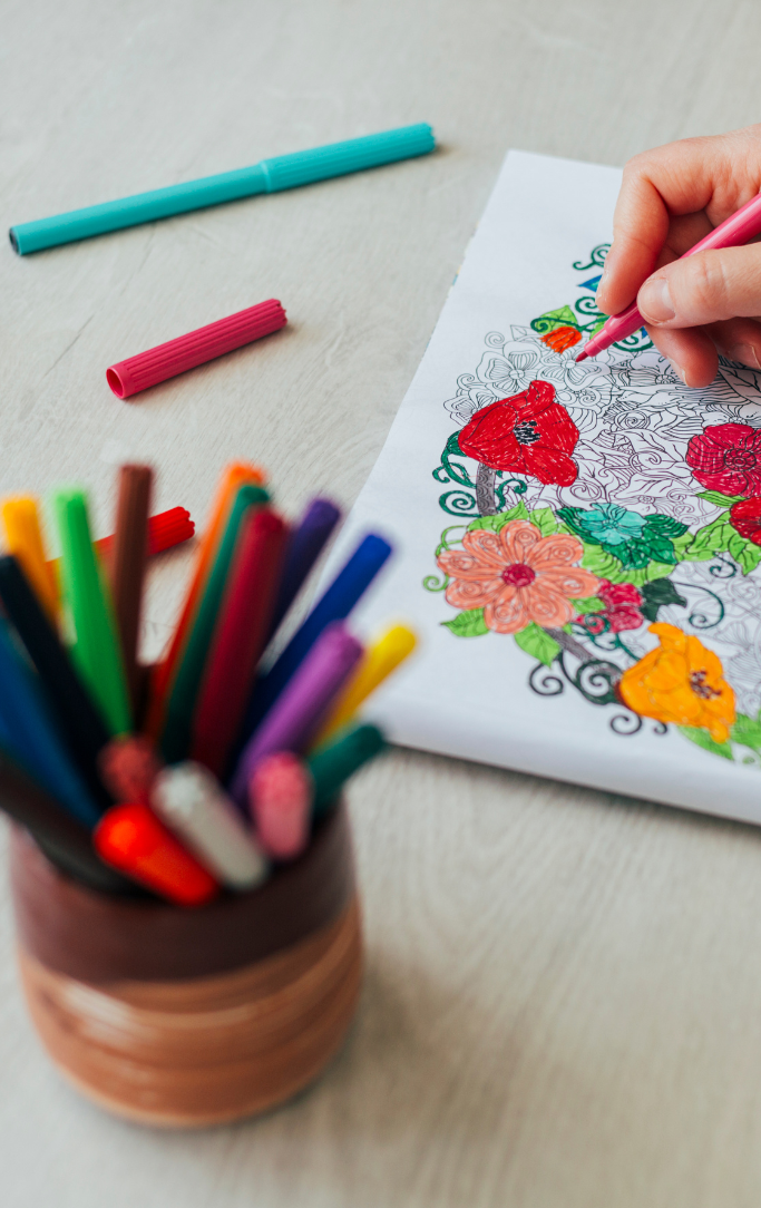 hand coloring a floral picture with markers