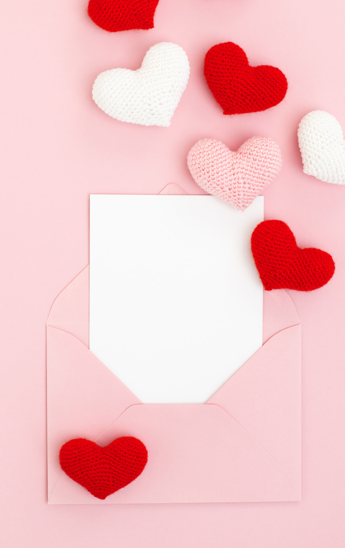 hearts coming from white envelope on pink background